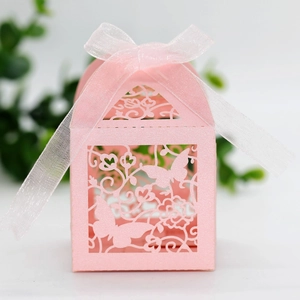 Detail of pink laser-cut wedding candy box with elegant butterfly and floral patterns