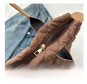 Gros plan sur la fermeture éclair lisse et le nylon matelassé d'un sac cabas marron