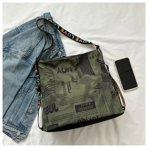 Detail der olivgrünen Hobo-Tasche mit Zeitungsdruck und LOVE-Schultergurt