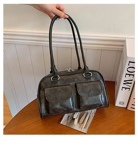 Close-up of black retro glossy leather underarm bag with silver hardware and dual pockets