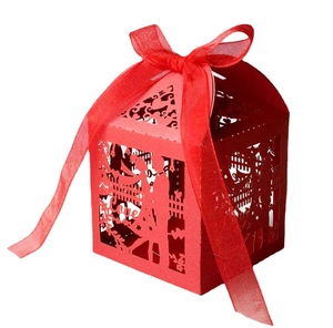 Detail of red laser-cut candy box with hollow couple silhouette and silk ribbon bow