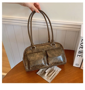 Detailed view of vintage brown underarm bag with double front pockets and textured surface