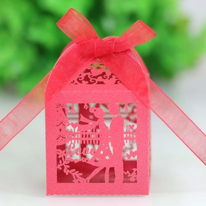 Detail of red hollow laser-cut wedding candy box with Love motif and ribbon bow