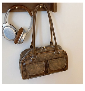 Retro brown leather handbag with double pockets hanging on a wooden rack with headphones