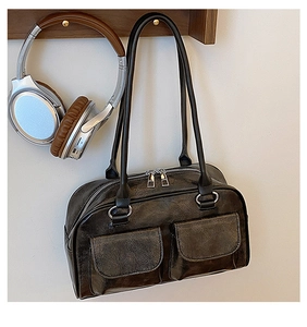 Close-up of vintage charcoal leather bag with two pockets and silver zippers