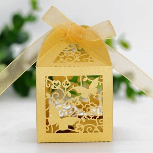 Macro shot of laser-cut butterfly and floral patterns on golden pearlescent wedding box