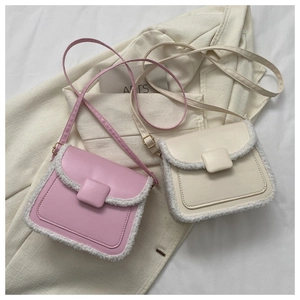 Detail of pink and cream small square crossbody bags with plush faux shearling trim decor