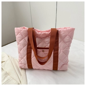 Detail of pink quilted puffer tote bag with brown handles and a functional front pocket