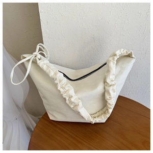 Off-white canvas dumpling bag with cloud-like scrunchie strap and bow detail