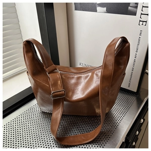 Close-up of vintage brown PU leather tote bag with pleated texture and adjustable strap