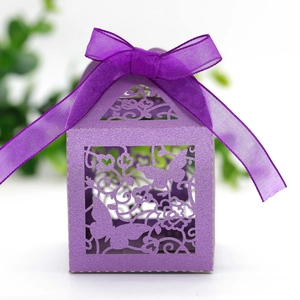 Detail of laser-cut butterfly design on purple pearl paper wedding favor box with ribbon