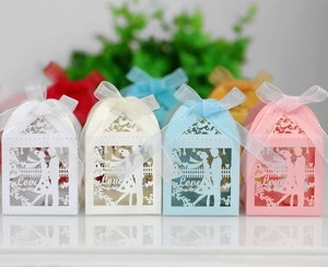 Laser-cut hollow wedding candy boxes in pastel colors with bride and groom silhouettes