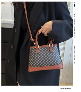 Detail of vintage pattern handbag with leather trim and gold metal hardware accents