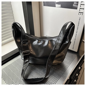 Detail view of large black hobo bag featuring glossy finish and adjustable silver buckle