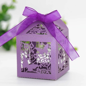 Detail of laser-cut butterfly wedding favor box in purple with elegant satin ribbon bow