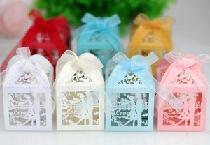 Detail of laser-cut wedding candy boxes with Love text and romantic couple silhouettes