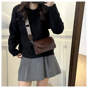 Bruine leren crossbodytas met brede vintage riem gedragen bij een winterse trui