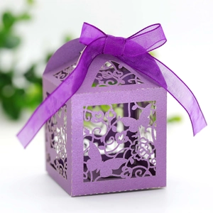 Detail of purple laser-cut wedding favor box with butterfly pattern and silk ribbon