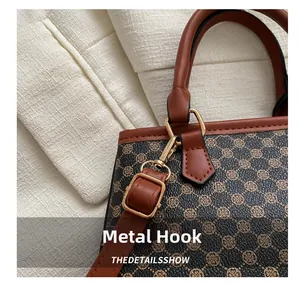 Close-up of vintage bucket bag featuring gold hardware hooks and leather stitching details