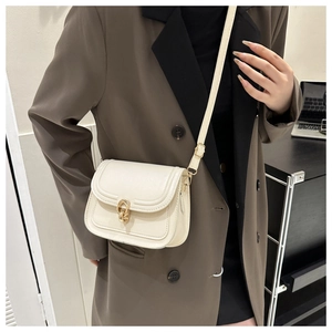 Détail du sac bandoulière crème avec fermoir fer à cheval doré et coutures de précision