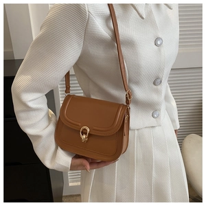 Détail du sac à bandoulière marron rétro avec boucle dorée et rabat en cuir synthétique