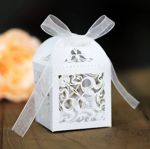 Détail de la boîte à bonbons blanche découpée au laser avec un nœud en ruban organza