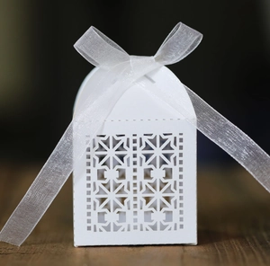 Detailed close-up of white laser-cut hollow candy box with elegant chiffon ribbon bow