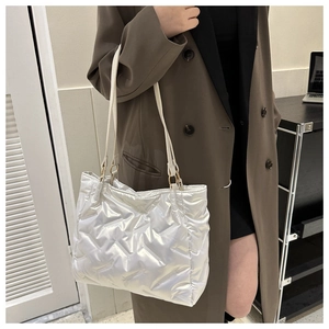 Détail du grand sac cabas argenté matelassé avec finition métallique et longues anses
