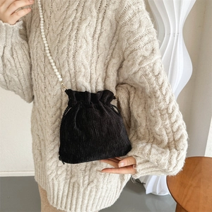Fashionable black corduroy drawstring bucket bag with elegant pearl chain strap and texture