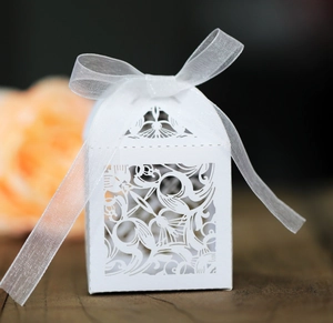 Vue détaillée du motif floral découpé au laser et du ruban blanc sur boîte à dragées de mariage