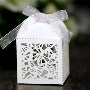 Detailed laser-cut white wedding favor box featuring intricate butterfly and floral patterns