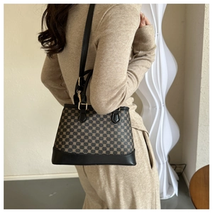 Model wearing a retro bucket bag with brown geometric patterns and black leather detail