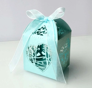 Vue détaillée du motif cœur et oiseau découpé au laser sur boîte cadeau bleu dégradé