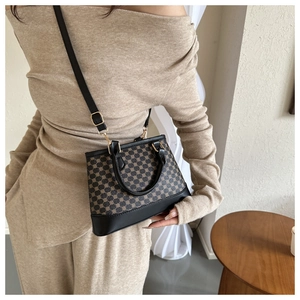 Detail of vintage geometric pattern handbag with leather handle and adjustable shoulder strap