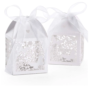 Detail of white laser-cut wedding favor boxes with butterfly patterns and silk ribbons