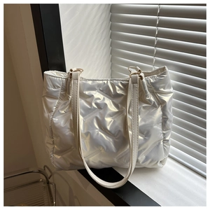 Détail du sac fourre-tout matelassé blanc nacré avec anneaux métalliques dorés et bandoulière