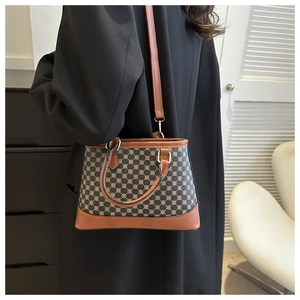 Detail of vintage monogram bucket bag featuring brown leather trim and metal handle loops