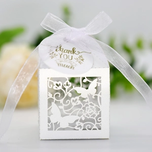 Close-up of laser-cut butterfly candy box with silk ribbon and thank you tag