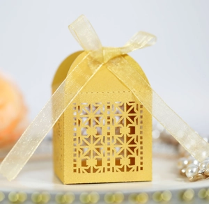 Detailed view of a golden laser-cut candy gift box with elegant ribbon and arched top