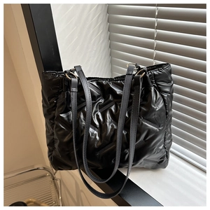 Détail du sac cabas matelassé noir montrant le tissu en nylon brillant et sa texture