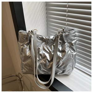 Détail d'un sac cabas argenté métallisé avec texture matelassée en V et fines anses