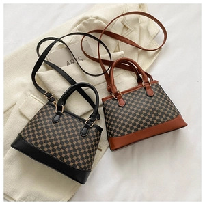 Detail of vintage patterned crossbody bags with leather handles and gold buckles
