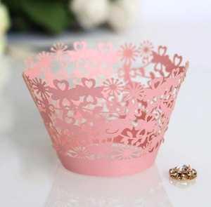 Vue macro des caissettes à cupcakes roses découpées au laser avec motifs de cœur et dentelle