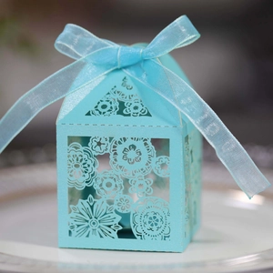 Sky blue laser cut favor box with intricate floral hollow design and ribbon bow