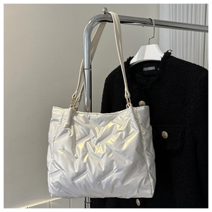 Détail du sac cabas matelassé blanc avec texture brillante et anneaux dorés