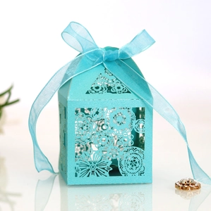 Detail of laser-cut floral pattern and organza ribbon bow on blue wedding gift box