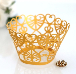 Detailed laser-cut heart pattern on gold pearlescent paper cupcake wrapper for weddings