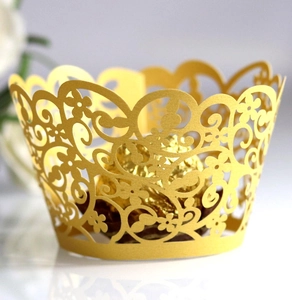 Detail der goldene lasergeschnittenen Muffinförmchen mit floralen Hohlmustern für Partys