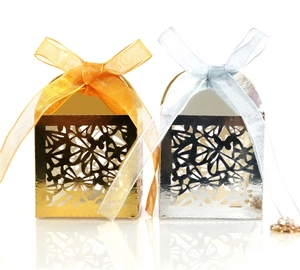 Macro detail of gold and silver hollowed floral candy boxes with elegant ribbon bows