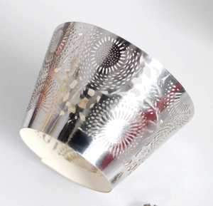 Close-up of laser-cut silver muffin liners with elegant sunburst lace pattern for wedding cakes